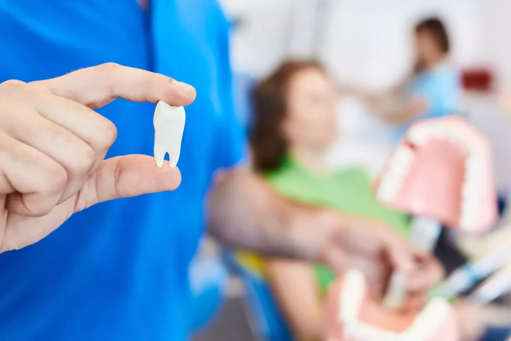 Dentist holding an extracted tooth in front of a patient at Dorri's Dental in Boynton Beach, FL