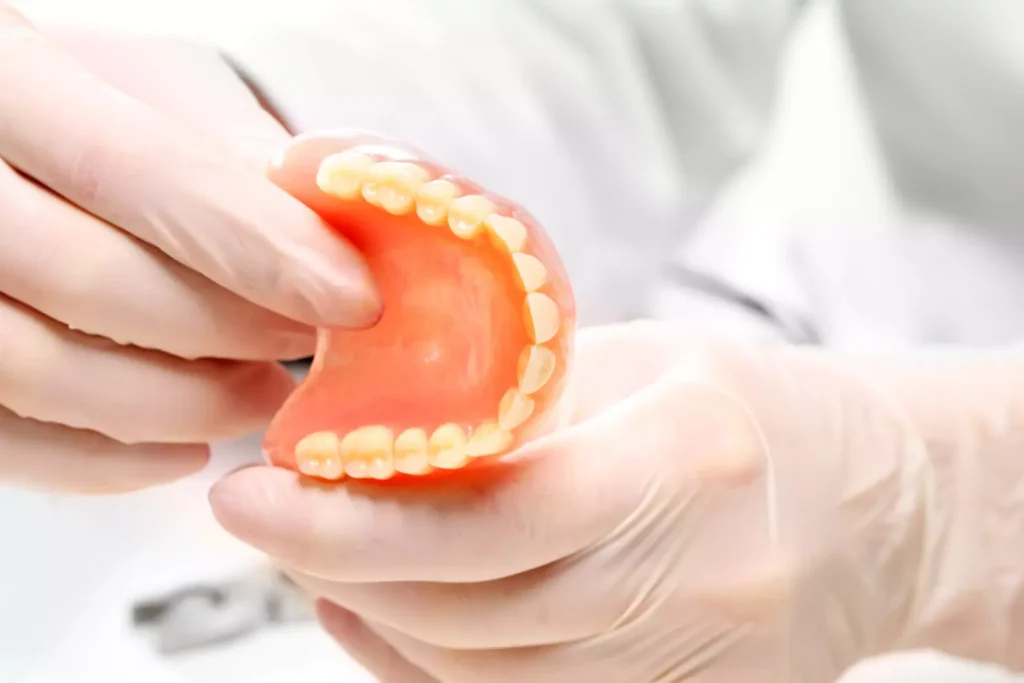 Dentist holding a custom partial denture at Dorri's Dental in Boynton Beach, FL