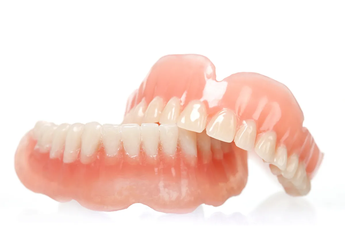 Close-up of snap-on dentures being held.