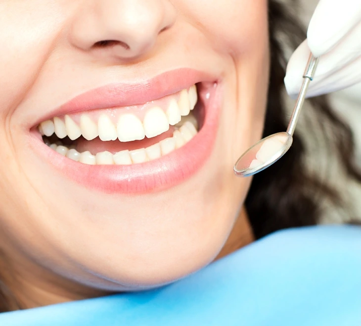 Patient smiling with restored teeth and a dental mirror at Dorri's Dental in Boynton Beach, FL