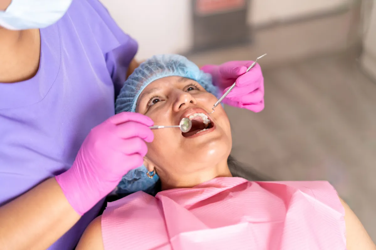 Close-up of a dentist using a scaler to clean a patient's teeth