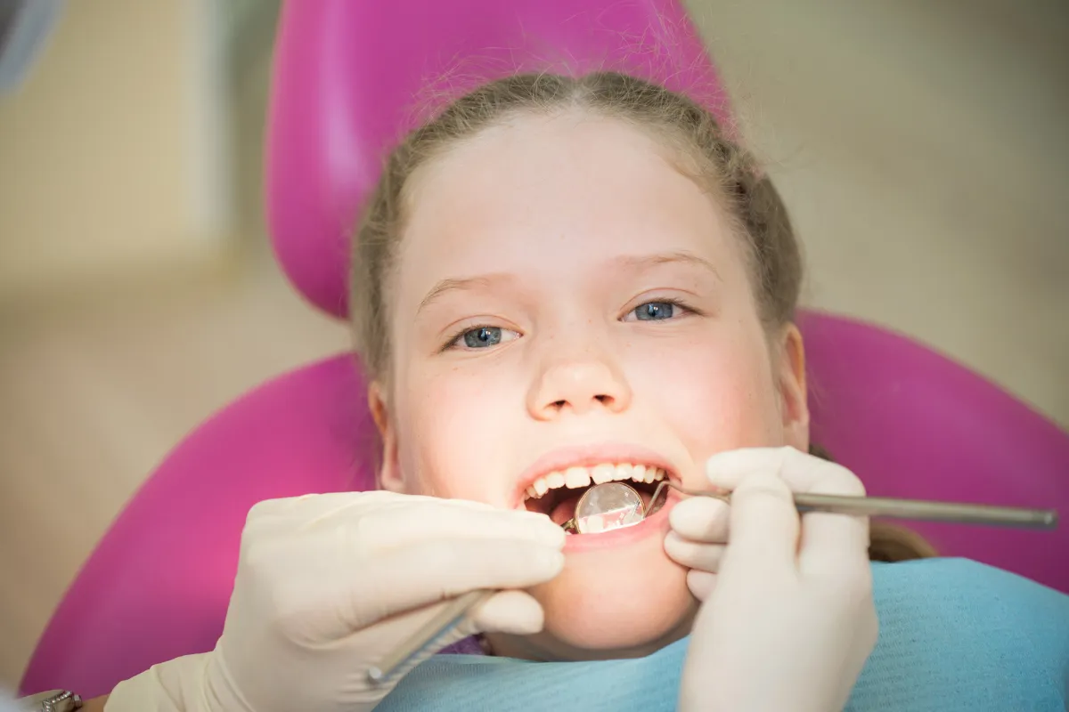 Dentist demonstrating brushing techniques to a child