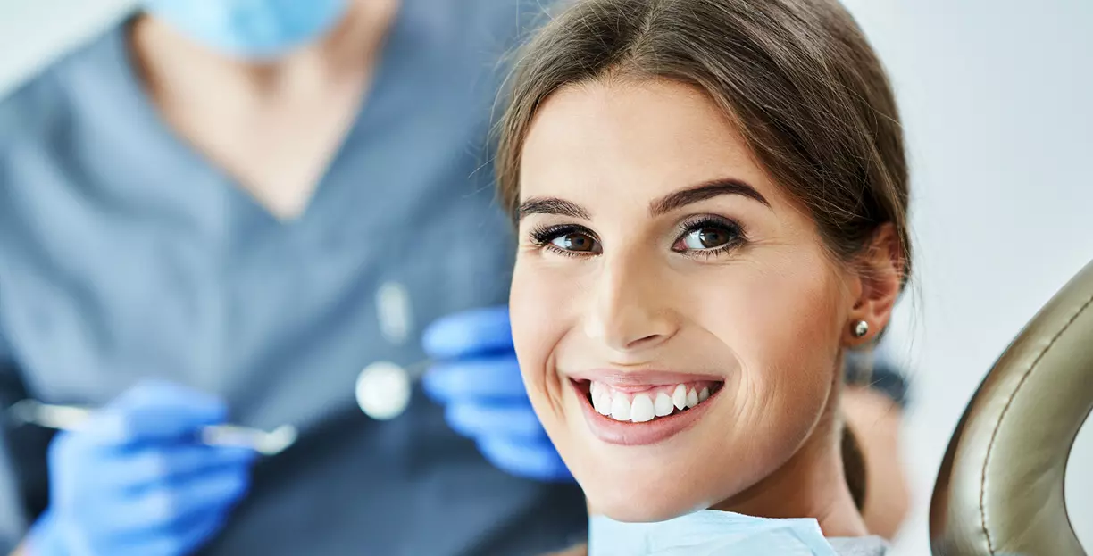 Dentist explaining dental insurance coverage for bridges and implants to a patient